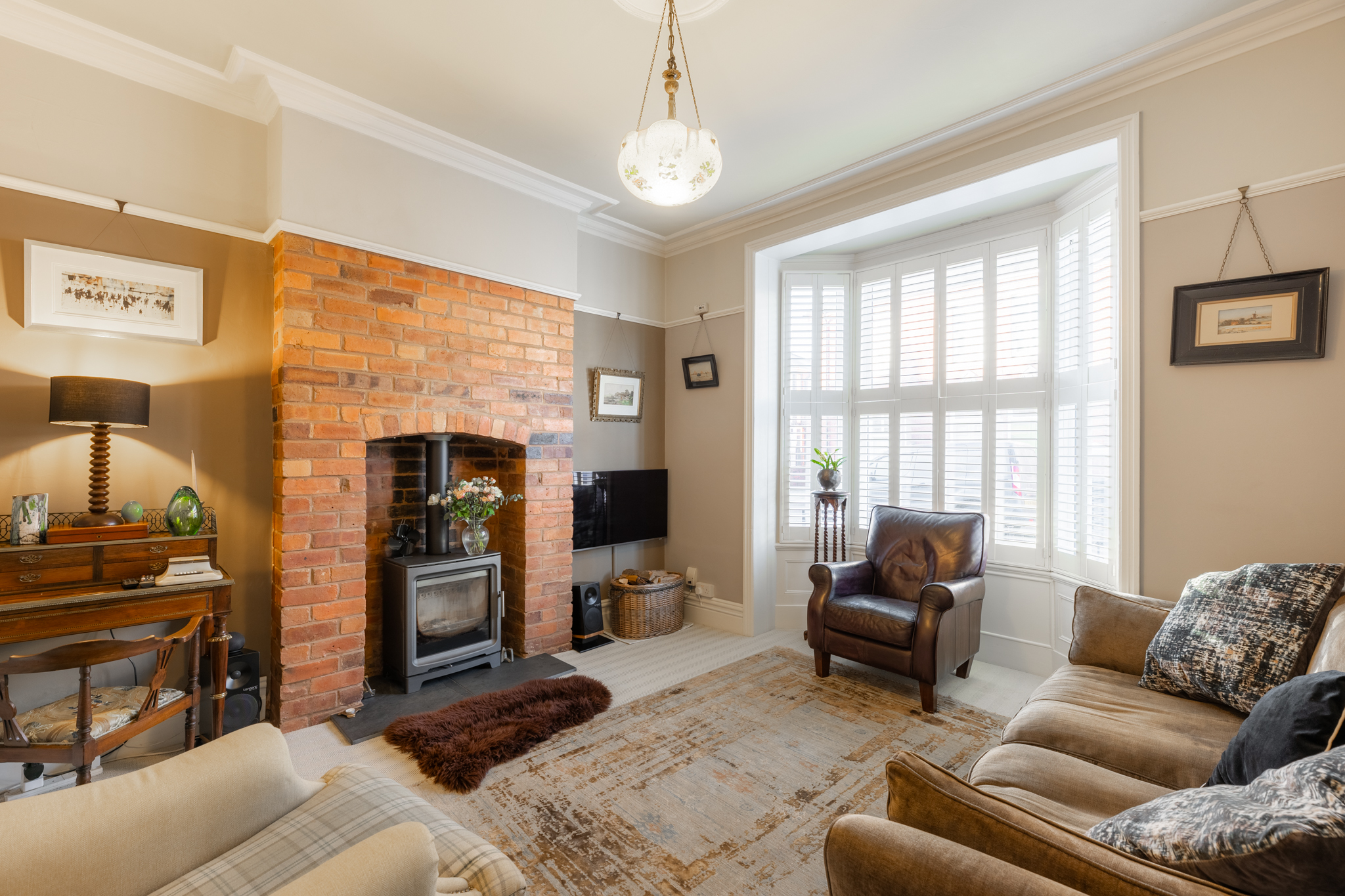 Characterful living room with a brick fireplace and bay window